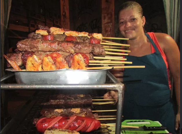 Aluna com bandeja cheia de espetinhos prontos
